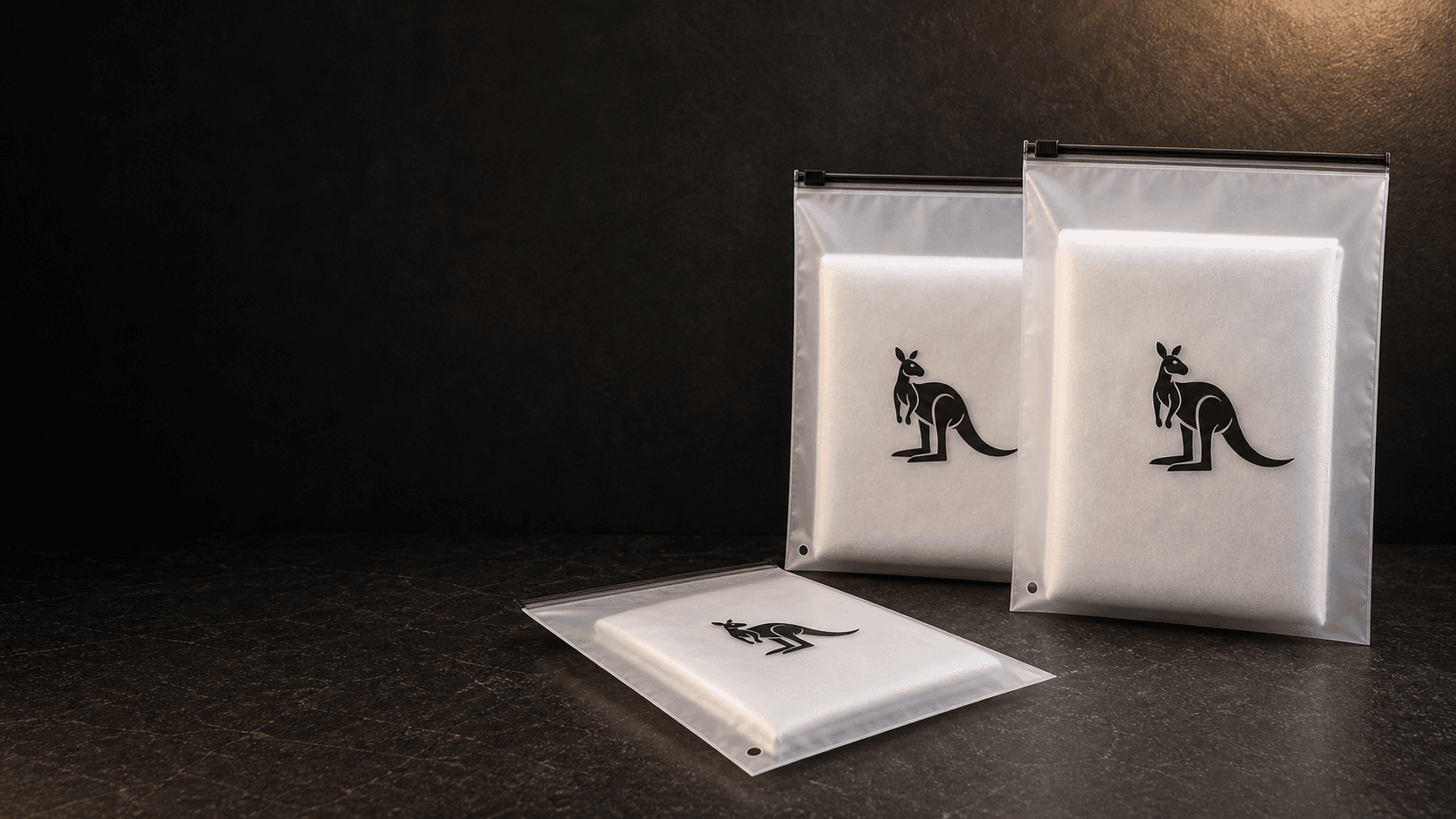 Sacos zip personalizados com acabamento fosco em bancada escura.